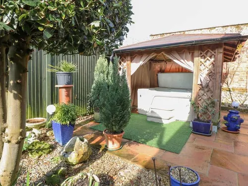 Lodge garden with covered hot tub and potted plants