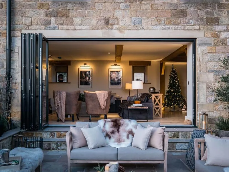 Stone exterior with open doors revealing The Malt Kiln living room and a Christmas tree inside