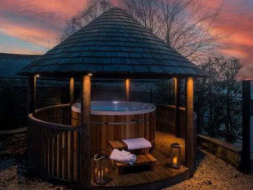 Cottage garden gazebo with wooden hot tub and steps