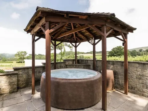 Private hot tub under a wooden gazebo