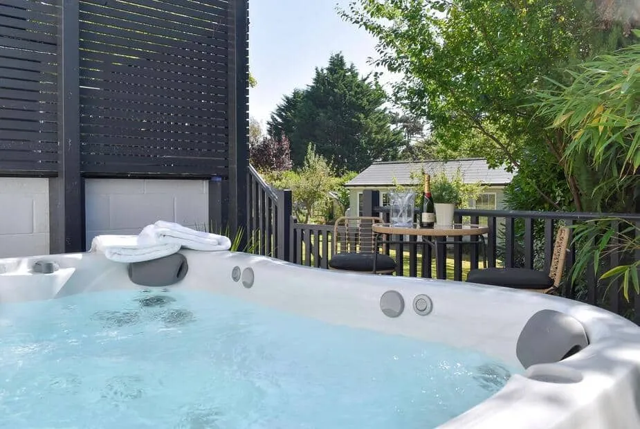 Outdoor hot tub and patio seating at The White House Retreat, with garden view