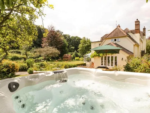 Cottage garden with outdoor hot tub and patio area
