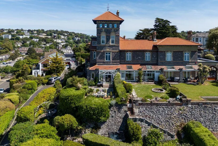 Vane Hall with terraced gardens and conservatory overlooking the hillside town.