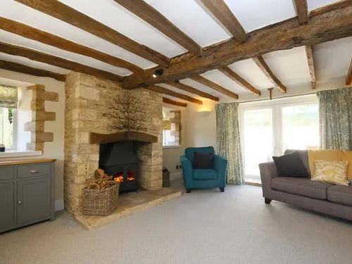 Cottage living room with exposed beams and stone fireplace
