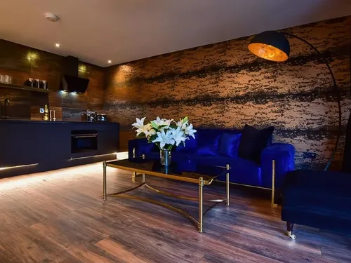 Lodge living area with blue sofa, glass coffee table and open kitchenette