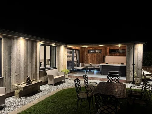 Lodge garden at night with outdoor seating and covered hot tub area