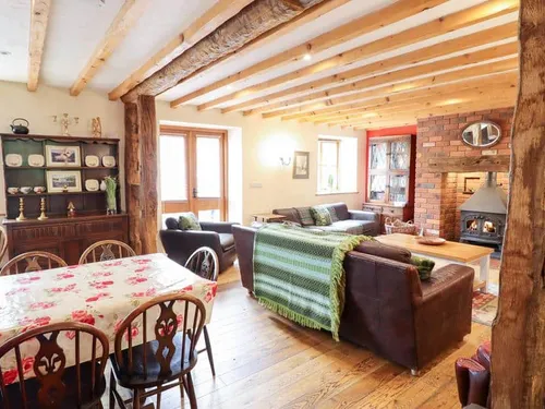 Cottage open-plan lounge with wood burner and dining table